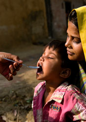 Mother holding child receiving medication.